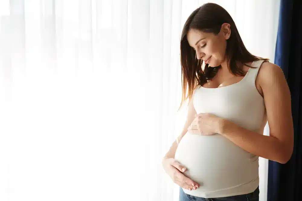 Tehotná žena pohladením po bruchu prejavuje väzbu s nenarodeným dieťaťom.
