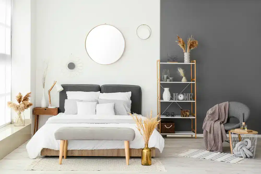 Alternatívny dizajn spálne s optimalizáciou priestoru, kde je jednoduché posteľné prádlo doplnené dekoratívnymi prvkami a rastlinami pre vytvorenie útulnej atmosféry.