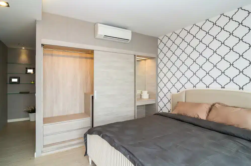 Moderná spálňa s výrazným vzorovaným tapetovaním a vstavanými úložnými priestormi, vhodná pre maximálne využitie priestoru v malom byte.