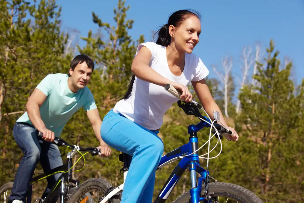 Pár jazdí na horských bicykloch, čo je ďalšia aktivita pre podporu metabolizmu.