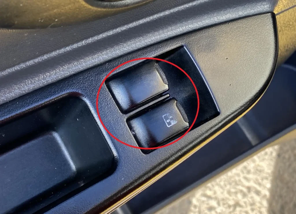 Opotrebované tlačidlá na dverách auta, ukazujú na časté používanie a mali by byť skontrolované pri kúpe ojazdeniny.