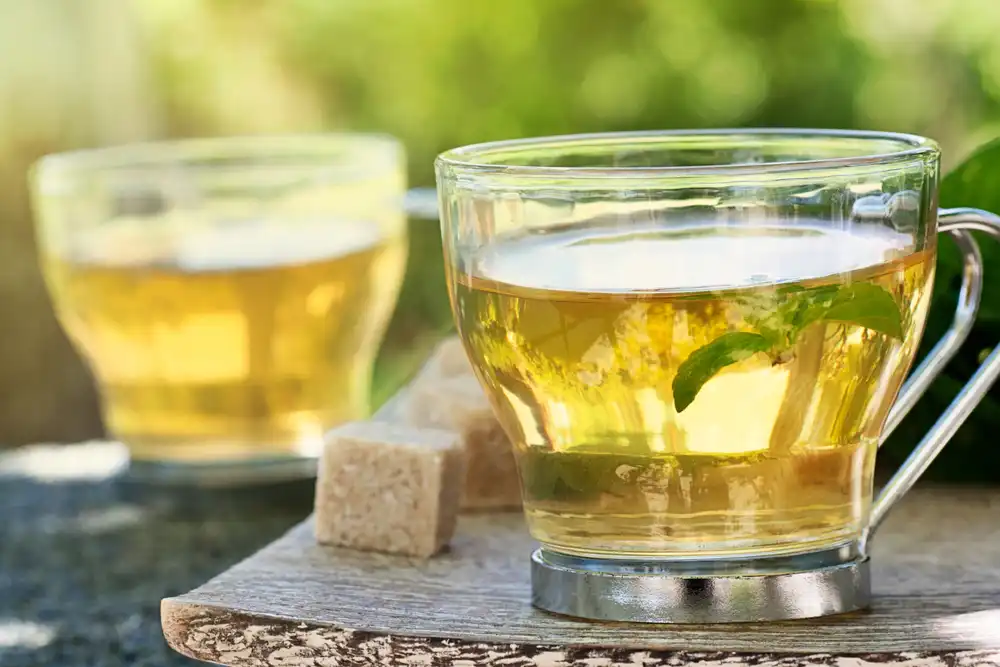 Šálka zeleného čaju, ktorý je známy pre svoje metabolizmus podporujúce vlastnosti.