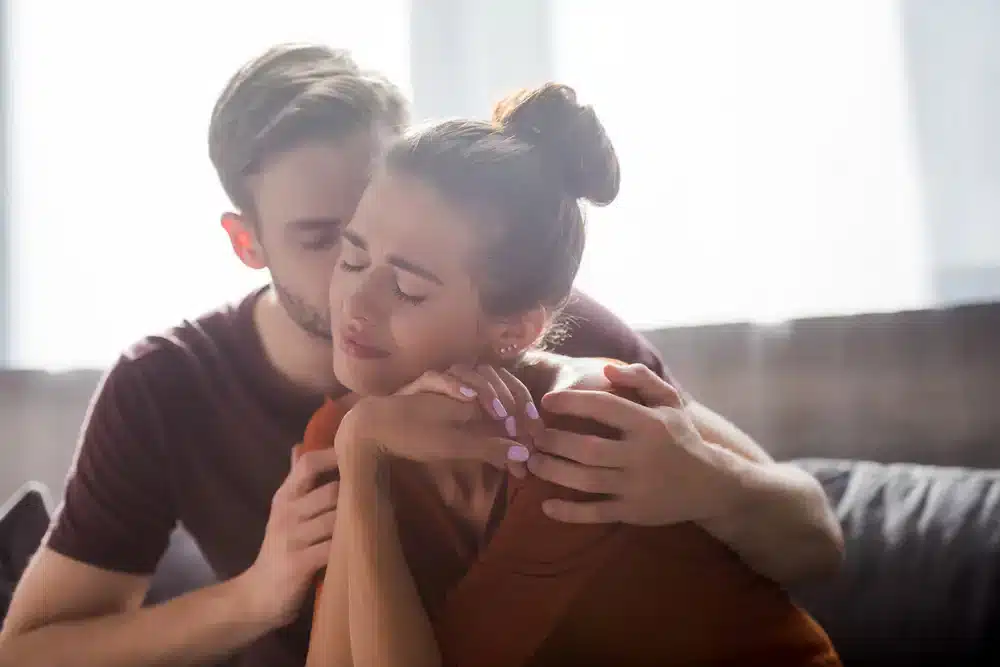 Partner utešuje svoju priateľku – podpora vo vzťahu napriek duševnému ochoreniu.